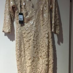 a dress hanging on a wall with a tag attached to the front and back of it