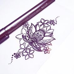 a drawing of a flower on paper next to a marker and pencil with the ink pen resting on it