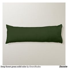 a green rectangular pillow sitting on top of a white wall