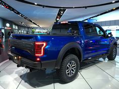 a blue truck is on display in a showroom