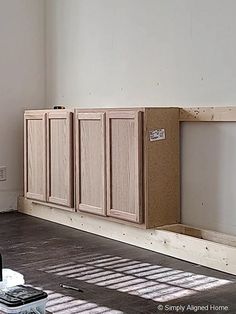 an unfinished kitchen cabinet is being built in the middle of a room with hard wood flooring