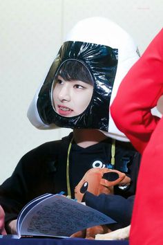 a young boy wearing a plastic bag over his head with a stuffed animal on it