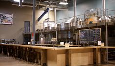 an empty bar with lots of stools around it