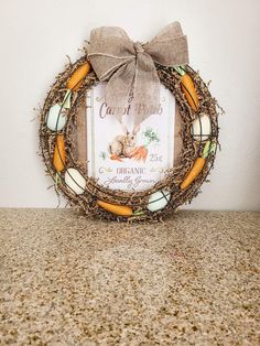 a wreath with a bow on top of a counter next to a sign that says carrots