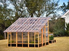 a small house made out of wood with a greenhouse attached to the roof and windows