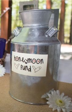 a metal can with a sticker on it sitting next to flowers and other items