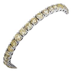 This exquisite bracelet features 11.00 carats of natural colored round brilliant fancy yellow and light yellow diamonds, set in 14 kt white gold. The vibrant yellow hues of the diamonds are beautifully complemented by the sleek white gold setting, creating a piece that exudes luxury and elegance. Certified by GCI for quality and authenticity, this bracelet is a dazzling addition to any jewelry collection, perfect for adding a touch of sophistication and brilliance to any occasion. Side Stones: ___________ Natural Diamonds Cut: Round Brilliant Carat: 11.00 cttw / 45 stones Color: Light Yellow - Fancy Yellow Clarity: SI-i1 Size: 18 cm Item ships from Israeli Diamonds Exchange, customers are responsible for any local customs or VAT fees that might apply to the purchase. **Import duties and ta Yellow Hues, Diamond Mines, Bracelet Tennis, Yellow Diamonds, White Gold Bracelet, Fancy Diamonds, Art Deco Diamond, Yellow Diamond, Tennis Bracelet