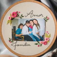 an embroidered photo frame with flowers and the words,'i amr familia '