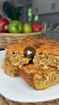 two pieces of banana bread on a white plate with apples in the backgroud