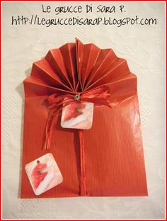 an origami fan is wrapped in red paper