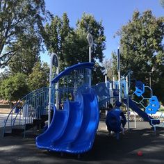 two children playing on a blue playground slide