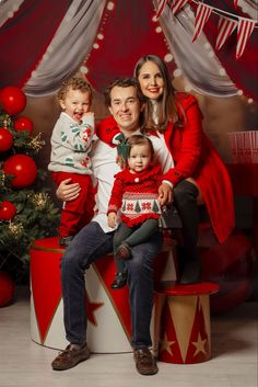 a family posing for a christmas photo in front of a christmas tree