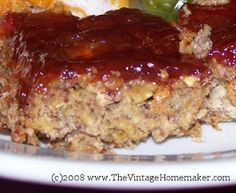 meatloaf with sauce and vegetables on a white plate, ready to be eaten