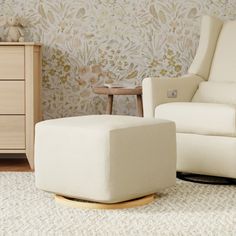 a white chair and ottoman in a room with floral wallpaper on the walls behind it