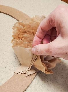 someone is making a wreath out of brown paper