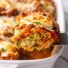 a spoon full of lasagna casserole with meat and cheese