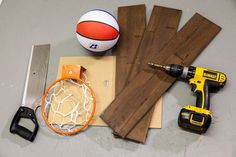 some tools are laying out on the floor next to wood planks and a basketball