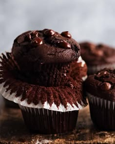 three chocolate cupcakes are stacked on top of each other