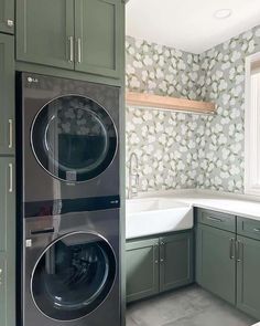 a washer and dryer in a kitchen with green cabinets