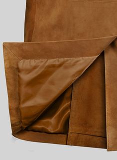 the back side of a brown leather chair with an open zippered pocket on it