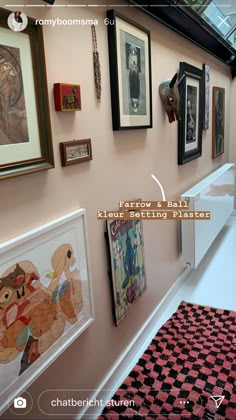 there are many framed pictures on the wall next to each other in this hallway area