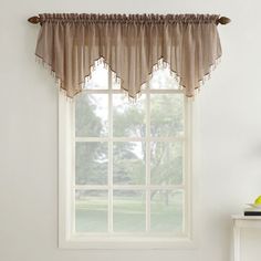 a window with a pink valance hanging from it's side in front of a white wall