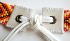 a close up of a white ribbon with beads on it