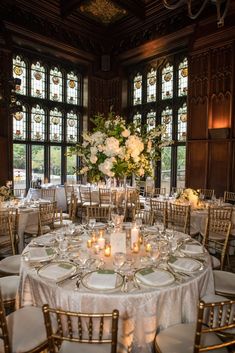 the tables are set with white linens and gold chairs for an elegant wedding reception