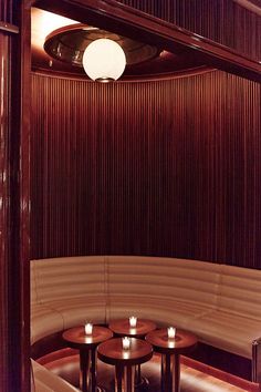 three round wooden tables sitting next to each other in front of a wood paneled wall