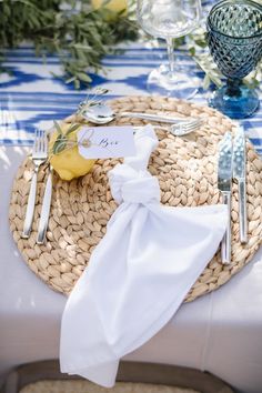 the place setting is set with silverware, napkins, and lemon wedges