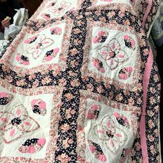 a bed covered in a pink and black quilt