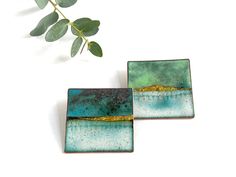 Landscape inspired square vitreous enamel brooch This stunning square brooch has been handmade using copper, vitreous enamel and 24ct gold foil.  Available in turquoise blue, pale green or lilac purple. To create the impression of a landscape layers of vitreous enamel in blue, turquoise, green and white were used to build up the depth and variation of colour. A slither of 24ct gold was added at the final stage to give the impression of a scene  - Brooch measures 40mm x 40mm - Sterling Silver plated brooch pin If you would like it to be gift wrapped in a Katie Johnston branded gift box please choose the option at checkout.  NOTE: Due to the way in which the enamel is applied there will be colour variation and no one piece will be exactly the same, and may vary from the image shown.  This ma 70th Birthday Presents, Ceramic Box, Vitreous Enamel, Green Blue Purple, Enamel Brooch, Bleu Turquoise, Jewelry Images, Branded Gifts, Enamels