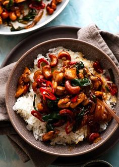 a bowl filled with rice and vegetables on top of a blue tablecloth next to another bowl