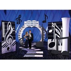 two people are standing in front of an assortment of musical instruments and music notes on display