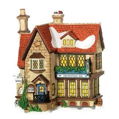 a figurine of a house with a bird on the roof and lights in the windows