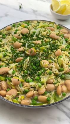 a pan filled with beans and broccoli on top of a marble countertop