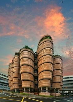 a large building with many round structures on the top and sides, in front of a parking lot