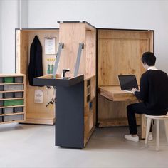 a person sitting at a desk with a laptop in a storage cabinet next to it