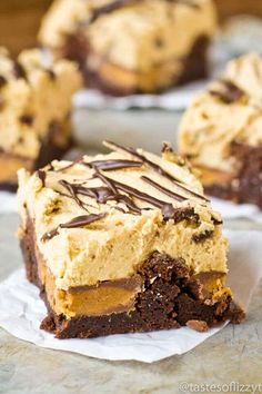 two pieces of cake with frosting and chocolate on top, sitting on paper towels