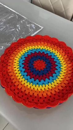 a colorful crocheted dishcloth sits on top of a table