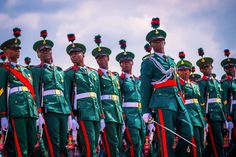 a group of men in green uniforms standing next to each other