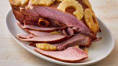 sliced ham and pineapples on a white plate