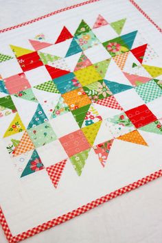 a quilted table topper with colorful triangles on it