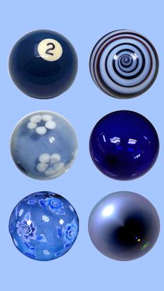 four different colored glass balls with numbers on the top one is blue, white and black