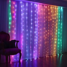 a chair sitting in front of a window covered in colorful string lights with curtains behind it