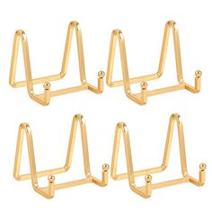 four gold metal triangle shaped hooks on a white background, set of five pieces in different sizes