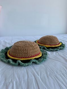 two crocheted hamburgers sitting on top of a bed