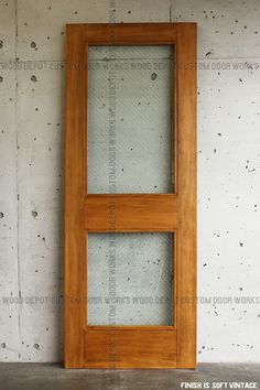 a wooden door sitting in the middle of a cement wall next to a brick floor