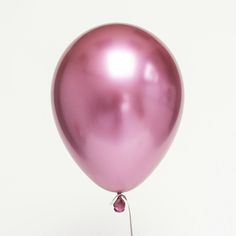 a pink balloon floating in the air with a string attached to it's end