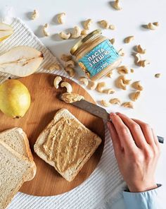 peanut butter and jelly sandwiches on a cutting board next to nuts, lemons, and walnuts